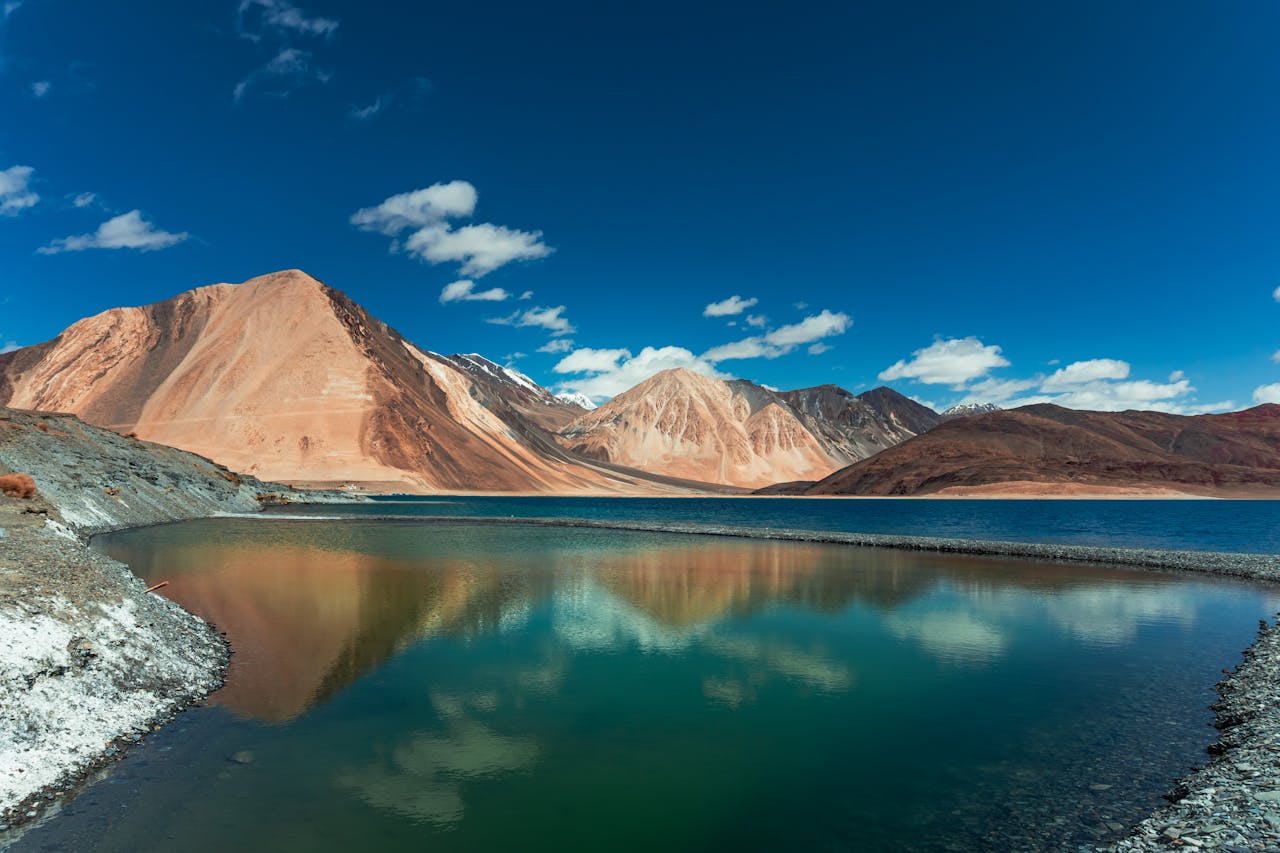 A Lake Near the Mountains Under the Blue Sky and White Clouds